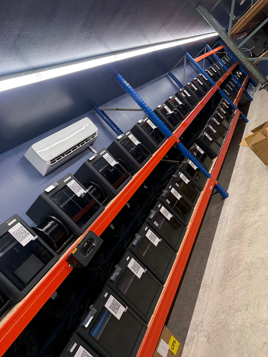 A row of Bambu Lab printers on the Farm Sip Supreme print farm in Lismore, Minnesota